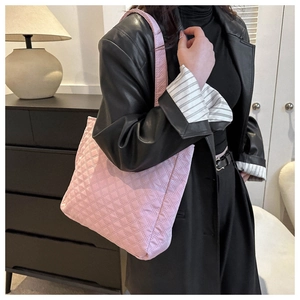 Close-up of pink quilted tote bag with soft padded texture and wide shoulder strap