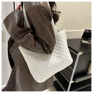 Lifestyle view of a large white quilted tote bag with diamond stitching for daily use
