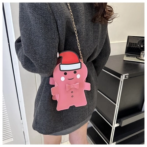 Gros plan d'un sac bandoulière bonhomme de pain d'épices rose avec chaîne dorée