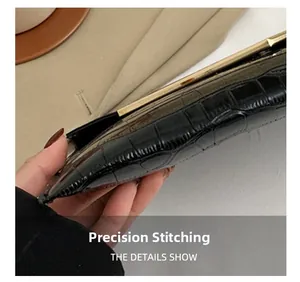 Macro detail of precision stitching on black crocodile pattern leather envelope clutch