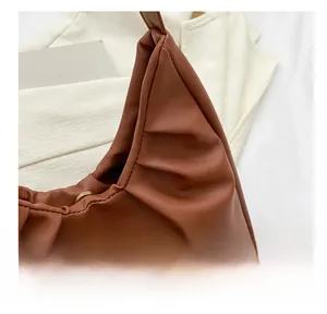 Detailansicht der karamellbraunen Faltenstruktur und des PU-Leders dieser Handtasche
