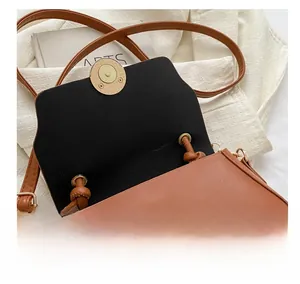 Close-up of brown faux leather bag featuring a gold magnetic closure and interior lining