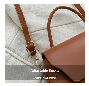 Detailed macro view of adjustable leather strap with gold buckle on brown box bag