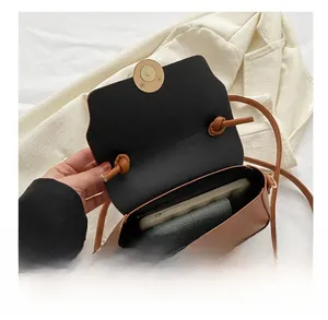 Detail showing the brown leather crossbody bag interior capacity for phone and wallet