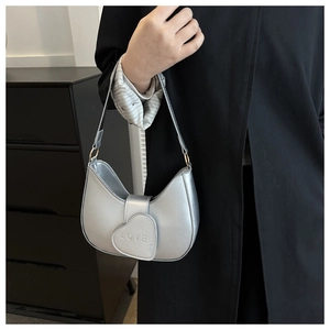 Borsa a mezzaluna argento con fibbia a cuore e goffratura LOVE portata a mano