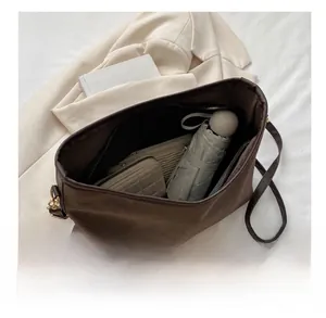 Interior storage view of dark brown suede tote bag showing umbrella and long wallet
