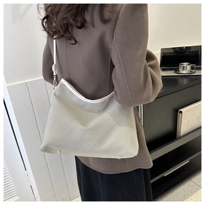 Detail view of stylish sage green crossbody tote bag with white trim and gold hardware