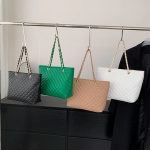 Borsa tote trapuntata con catena in quattro colori eleganti appesa a un supporto di metallo