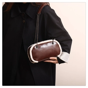 Détail d'un sac en cuir marron avec bordure en similicuir blanc et chaîne en métal