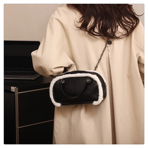 Détail du sac bandoulière en cuir noir avec bordure en fausse fourrure blanche et chaîne
