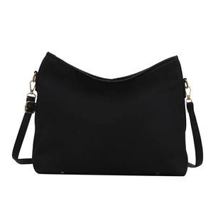 Classic black nylon tote bag with gold hardware and adjustable strap on white backdrop