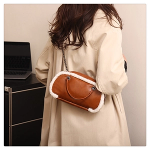 Détail d'un sac en cuir marron avec bordure en similicuir d'agneau et bandoulière chaîne