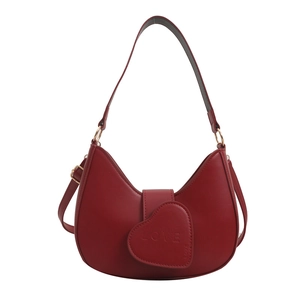 Minimalist red hobo bag with heart LOVE embossing and adjustable strap on white background