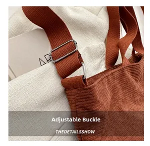 Close-up of adjustable metal buckle on brown corduroy shoulder bag strap