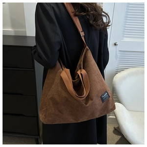 Detailed texture of brown corduroy tote bag with Fashion label and sturdy shoulder straps