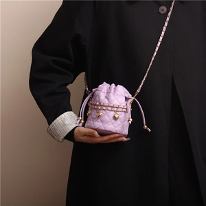 Violette Stepp-Beuteltasche mit Goldkette und Herzanhängern am Modell