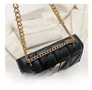Close-up of quilted black leather shoulder bag with gold metal logo and chain strap