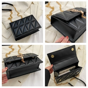 Detail of black quilted crossbody bag with triangle stitching and golden tassel hardware