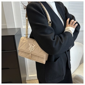 Detail of beige quilted leather crossbody bag with gold VS logo and chain strap
