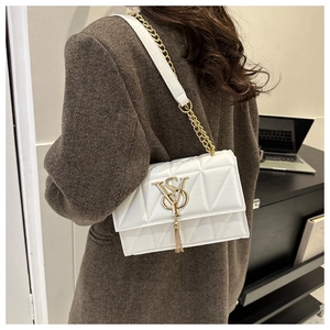 Detail of white quilted crossbody bag with gold VSY logo and elegant tassel fringe