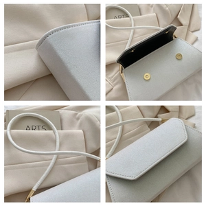 Detailansicht der silbernen Glitzer-Clutch mit Struktur und goldener Hardware