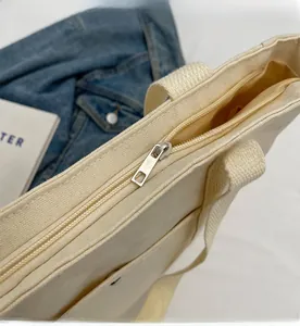 Gros plan détaillé de la fermeture éclair en métal argenté sur le sac en toile beige