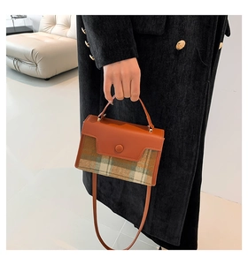 Detail of vintage plaid handbag with brown leather flap and green checkered fabric