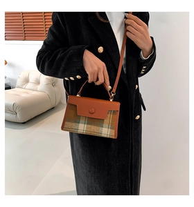 British style checkered wool and brown PU leather handbag detail on a model