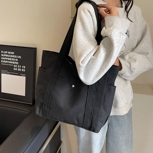 Grand sac cabas minimaliste en toile noire avec poche avant et poches latérales pour femme
