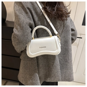 Détail du sac à bandoulière blanc avec fermoir doré et logo FASHION en gros plan