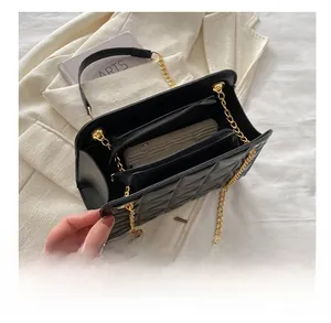 Internal view of black quilted crossbody bag showing compartments and gold chain strap
