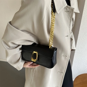 Minimalist black leather shoulder bag with golden horseshoe buckle and chain strap