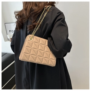Detail of light beige quilted crossbody bag with golden chain and diamond pattern
