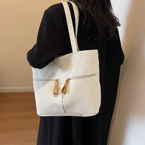 Solid color corduroy tote bag in off-white with dual front zipper pockets for women