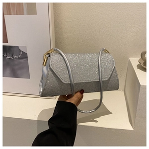 Nahaufnahme des silbernen Glitzermaterials und der goldfarbenen Schnalle der Damenhandtasche