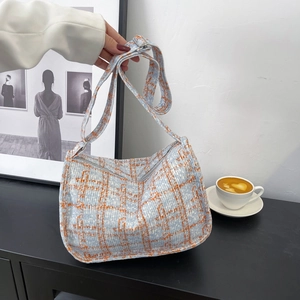Blue and orange checkered small pillow bag with adjustable strap shown by model