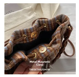 Detailed macro view of metal magnetic buckle on brown plaid bucket handbag