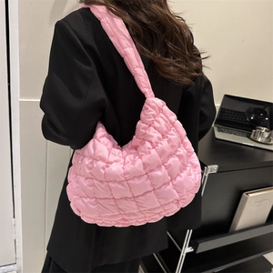 Pink quilted cloud shoulder bag made of glossy puffer nylon fabric worn by model