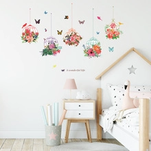 Detailed view of floral birdcage and butterfly wall decals on a clean white nursery wall