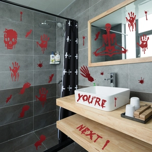 Close-up of Halloween bloody handprints and skull decals on bathroom tiles