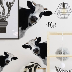 Macro detail of black and white cow wall stickers with 'Hi' text in a home setting