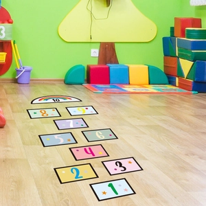 Close-up of colorful hopscotch floor stickers with numbers 1 to 10 and rainbow patterns