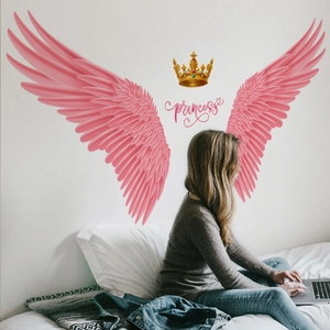 Detail of pink angel wings and golden crown princess wall stickers on bedroom wall