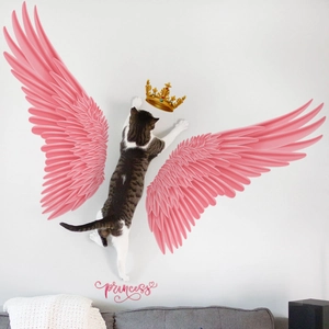 Pink angel wings and gold crown wall decal with princess text over a modern sofa