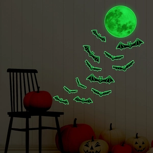 Detailed view of glow-in-the-dark Halloween moon and bats stickers on a dark textured wall