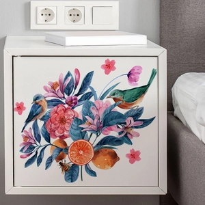 Floral wall sticker with birds and flowers applied on a minimalist white bedside cabinet