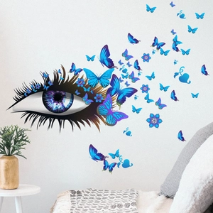 Détail de l'autocollant mural œil et papillons violets sur un mur blanc de salon