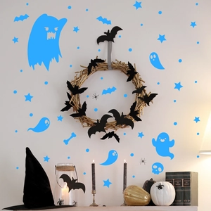 Halloween wall stickers featuring blue ghosts and black bats in a cozy indoor holiday setting