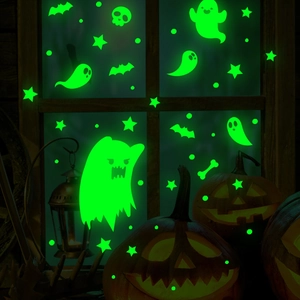 Luminous Halloween wall stickers featuring ghosts and bats glowing green on a window