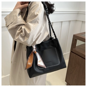 Détail d'un sac cabas en cuir noir avec surpiqûres blanches et foulard en soie